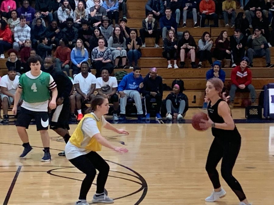 During the second quarter, physical education teacher Jody Chambers attempts to cross junior Sydney Bateman to make a basket. “I volunteered for it thinking there was no way I would be picked, though I did play basketball last year,” said Bateman.