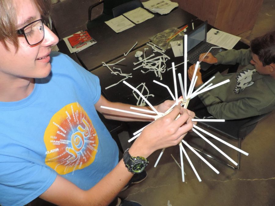 Sophomore Aidan Johnson puts the finishing touches on his egg drop device made of nothing but straws and tape. Unfortunately, Johnsons contraption failed to protect his egg, and the egg broke on impact.