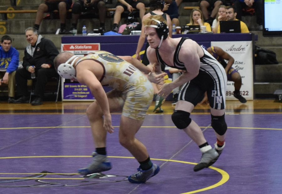 Team captain, junior Logan Mosier, competes against Holden Smart of Missouri Military Academy in neutral position. Mosier had just broken his nose, but decided to keep fighting, eventually outscoring him in round one.