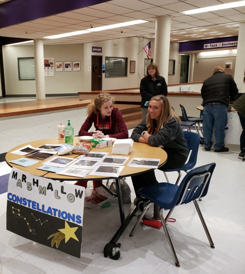 Senior Amy Jordan and and junior Jacquelyn Tope prepare their table for Stargazing Night guests. Their station includes making star constellations out of marshmallows and pretzel sticks or toothpicks, a popular attraction among the younger kids.