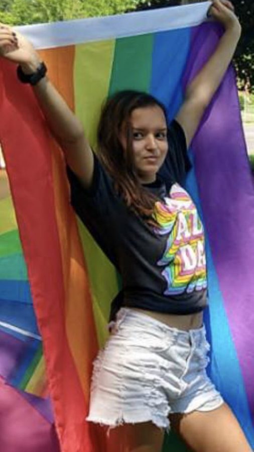 Senior Sarah Mueller Shares Her Aspirations to Sing
Caption: At a gay pride picnic, Sarah Mueller shows her pride and courage with the LGBTQ+ flag. “You need courage to put yourself in front of people and accept criticism, because criticism and discomfort are what help you grow as an artist. You need pride to be proud enough of what you’re doing to keep doing it, even when it drives you crazy,” said Mueller.