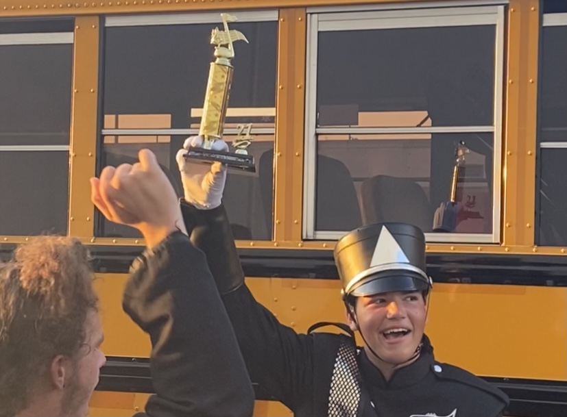 Placing third overall along with winning the best percussion caption award, senior drum major Duncan Bertier hoists the third-place trophy. “It felt great, do I think that we should have placed higher? Yes, we should have and we will place higher,” said Bertier.