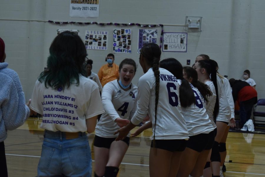 Senior Gabby Bowring high fives her teammates as they cheer her on during the senior line up. “We all had so much fun together, we always do but we were all really energetic for this  game,” said Bowring.
