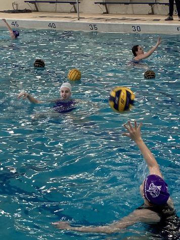 As a warm-up for practice sophomores Athena DeKinder and Anna Zwibelman practice throwing and catching the ball. In water polo, player have to throw and catch the ball in a certain way with one hand. Goalies are allowed to use both hands.