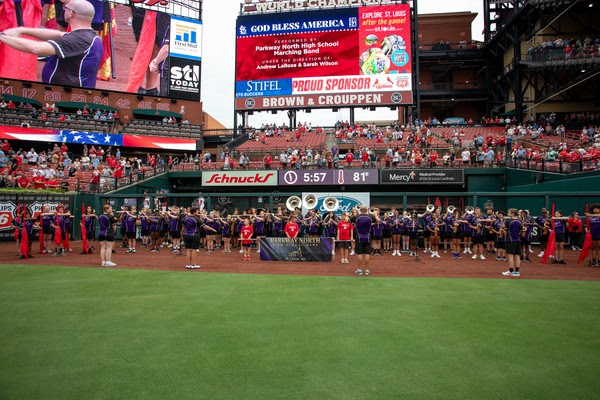 Senior Elizabeth Fuehne and junior Ethan Denny, with help from band directors Andrew LaRose and Sarah Wilson conduct the Parkway North Marching Band at the Cardinals Game on Aug. 8. "I thought it went great. We've done this for a long time, and it's a great way to kick off our season,"  LaRose said.