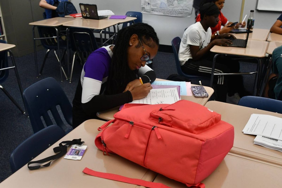 Sophomore Brooke Johnson completes homework right before she cheers for the varsity football team at Parkway Central High School on Sept. 13. Cheerleaders must balance their schoolwork and social life with practice and performances which is not always easy to do.