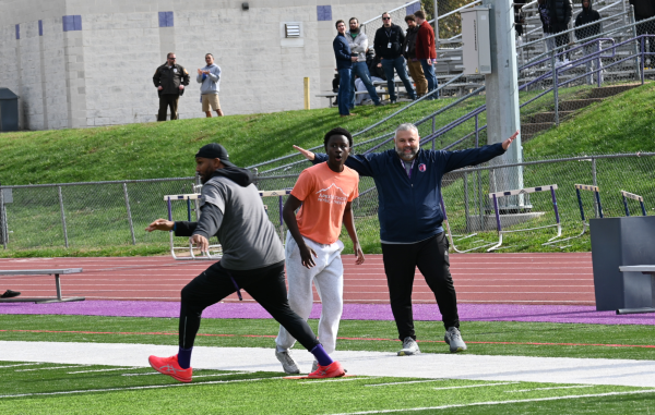 Matt Alonzo declares Jon Hardy safe at first base while fellow staff members look on. Both staff and students were invested in the game’s outcome, each cheering on their team. 