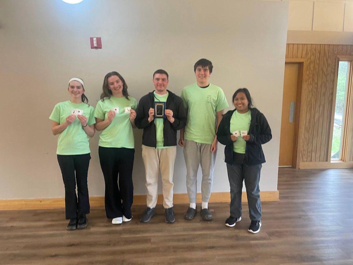 Juniors Norah Huntebrinker and Auriana Roy, senior Matt Andrews, freshman Ryan Hunterbrinker, and sophomore Daphne Nuestro posing for a picture after winning their award on April 3. Andrews holds the plaque with other teammates holding cards. 