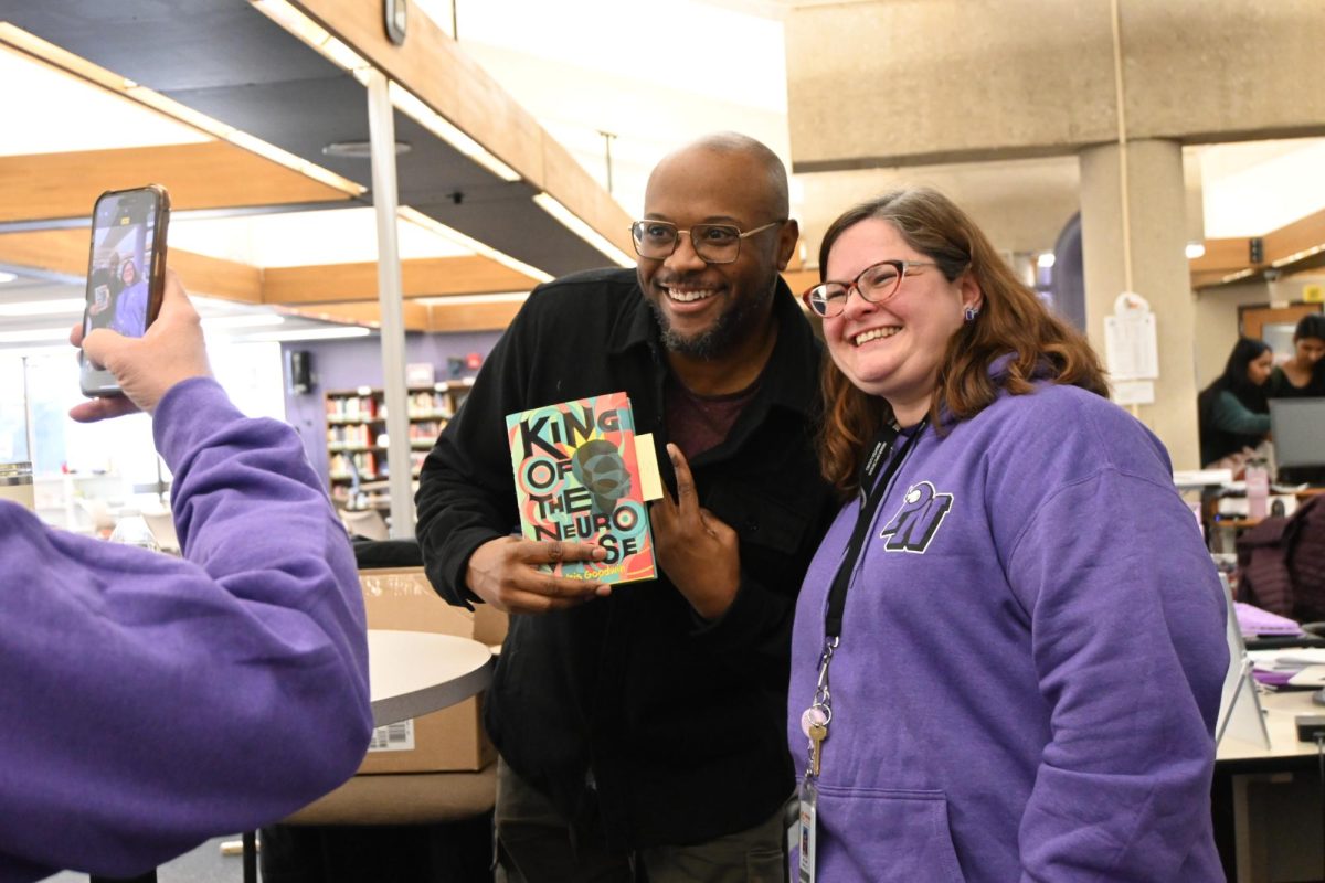 Author Idris Goodwin poses for a selfie with Librarian Melanie Whiteley after autographing her copy of his newly published book, capturing a light-hearted moment at the end of his visit.