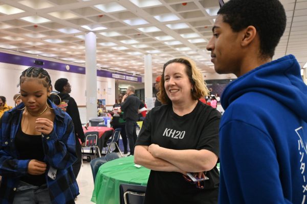 ESOL teacher Tricia Frank is all smiles as she views sophomore Zay Allen's poster about African-American musicians from our generation. 